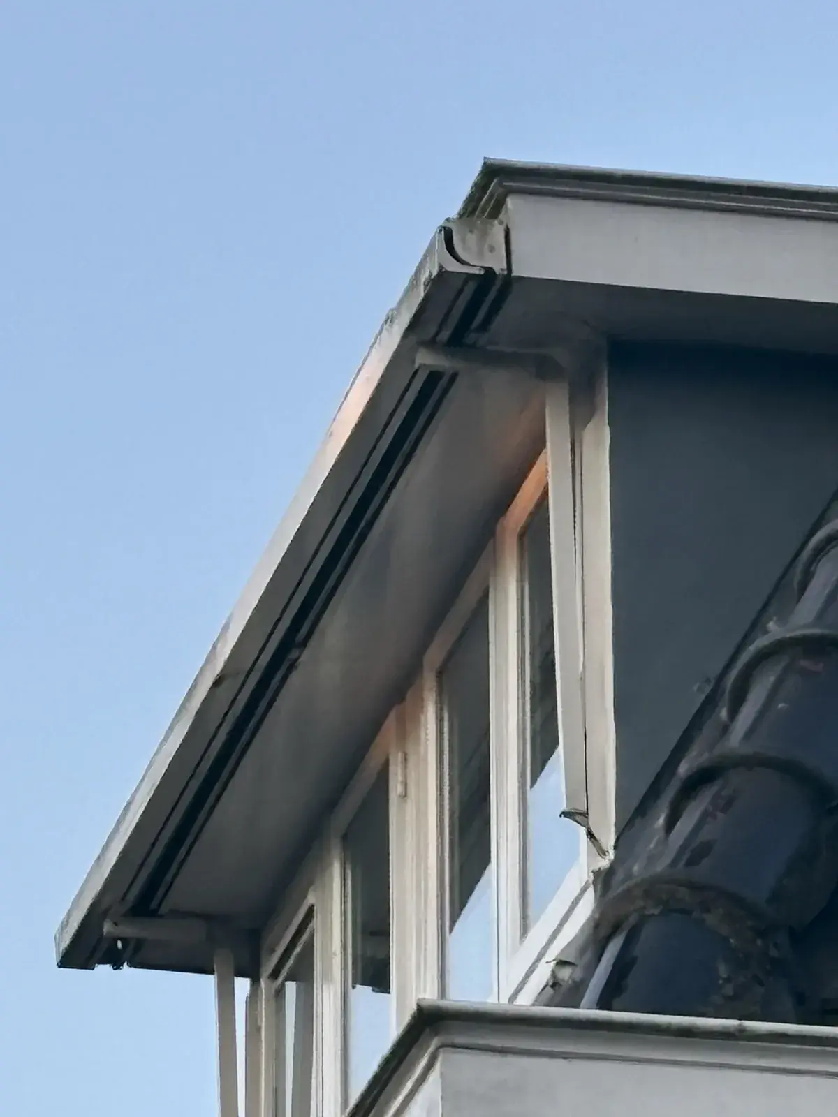 Dakkapel met een overstek vlak boven het raam, waardoor er nauwelijks montageruimte is voor zonwering